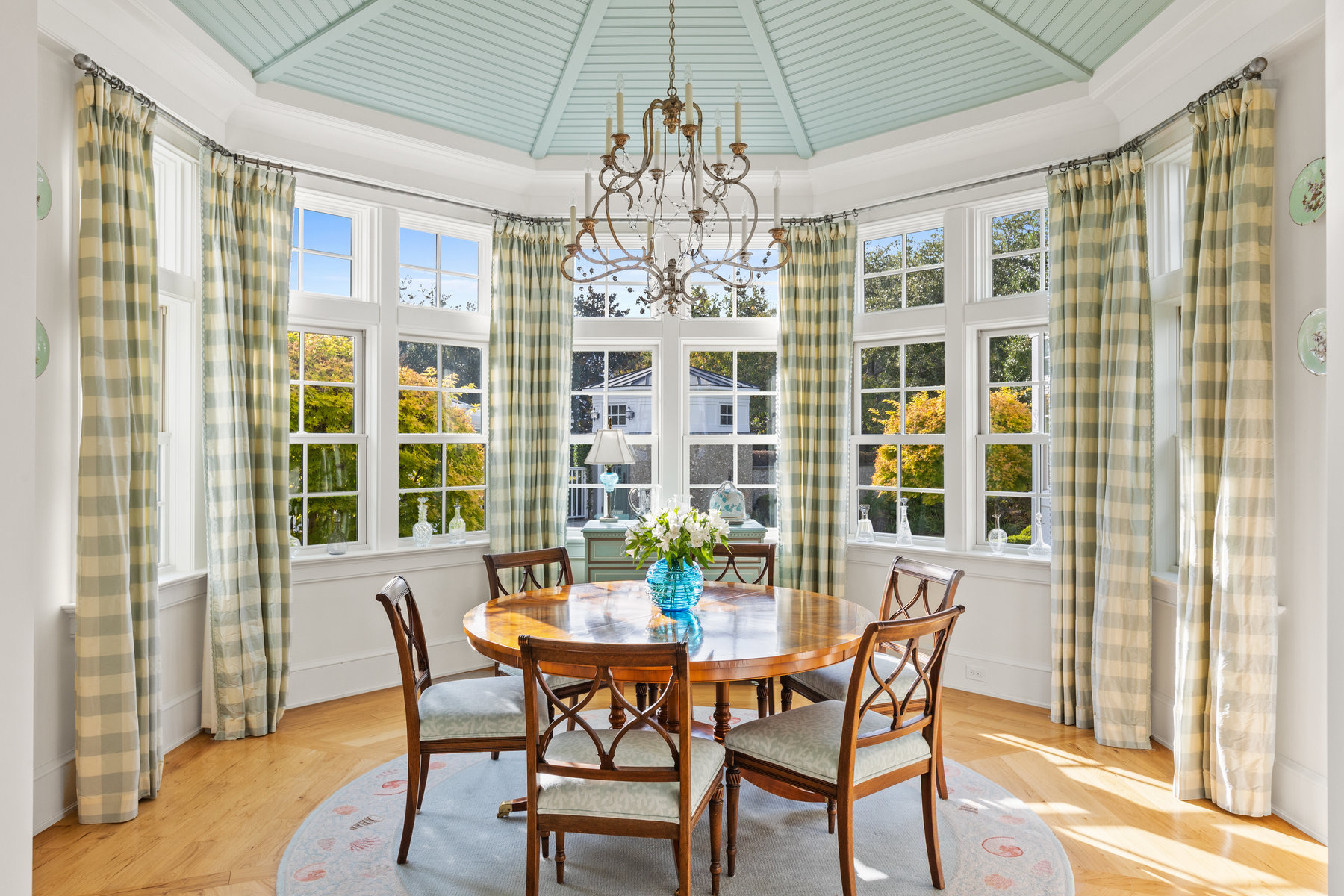 Sunny dining room with blue ceiling and checked curtains