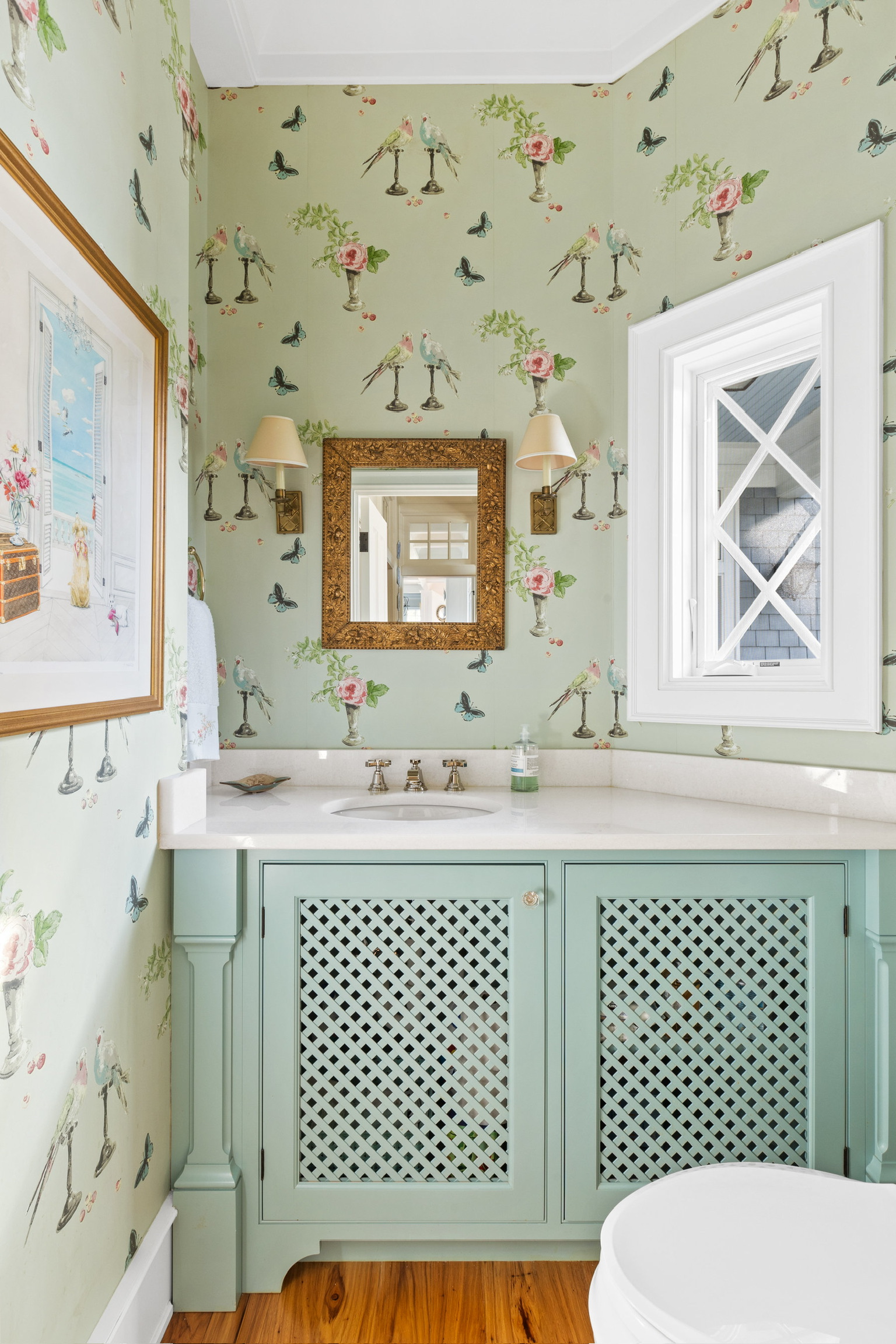 Powder room with patterned wallpaper and pale blue cabinetry