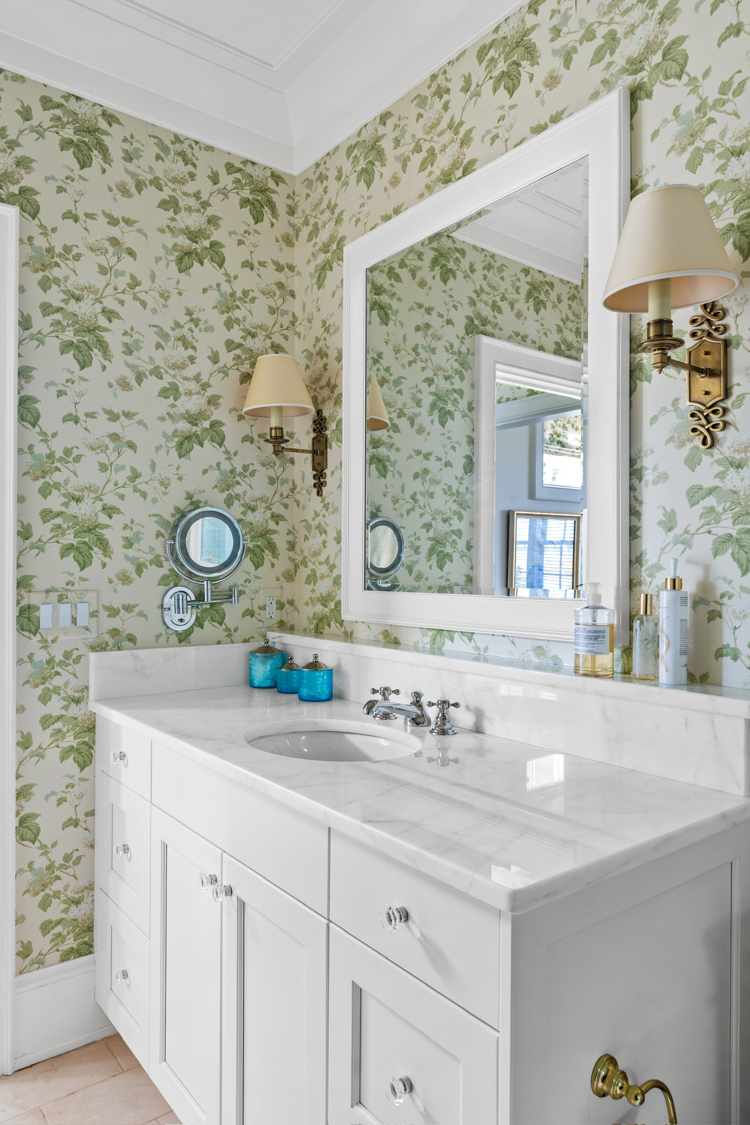 Bath with floral wallpaper and white vanity